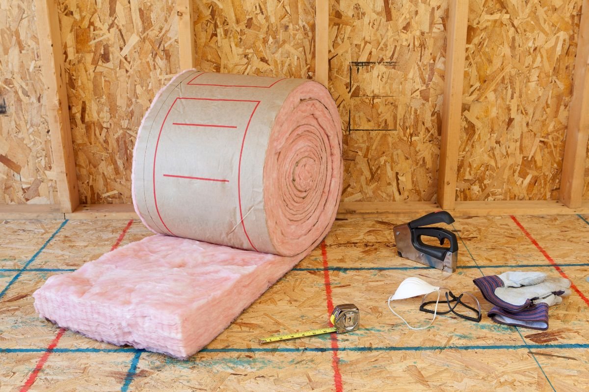 A roll of pink insulation material placed on the floor, indicating a service related to insulation installation.
